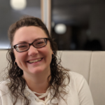 woman Emily Grabatin in white shirt smiling