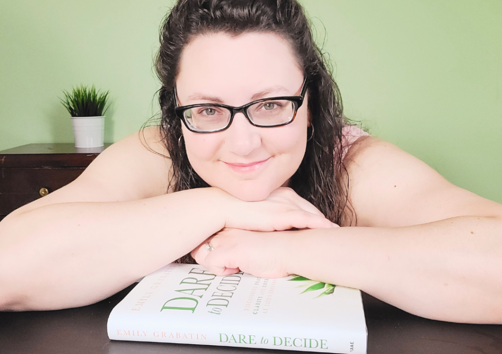 Emily Grabatin smiling over her book Dare to Decide